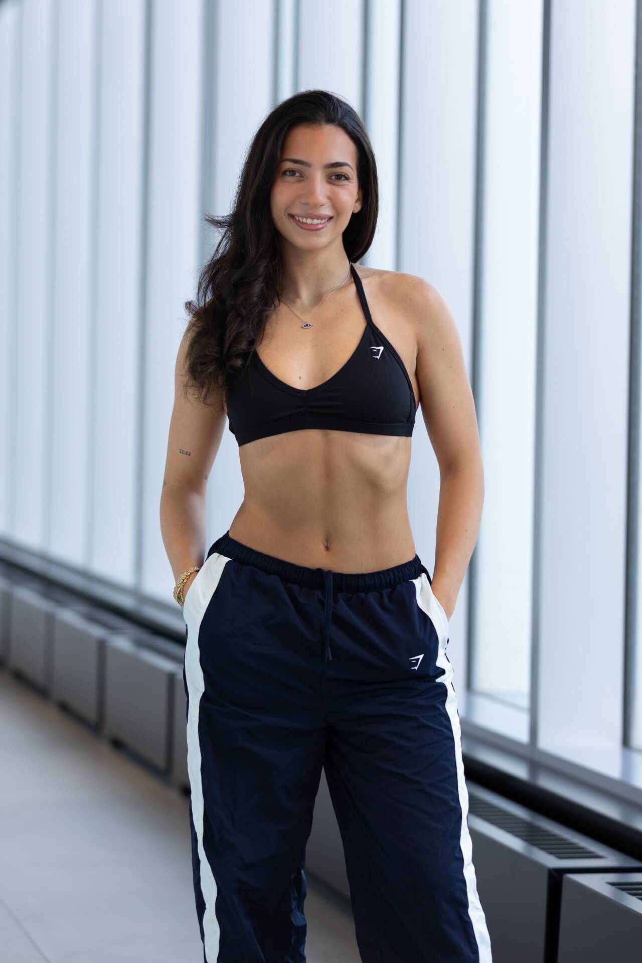 Athletic female in fitness apparel standing smiling at the camera
